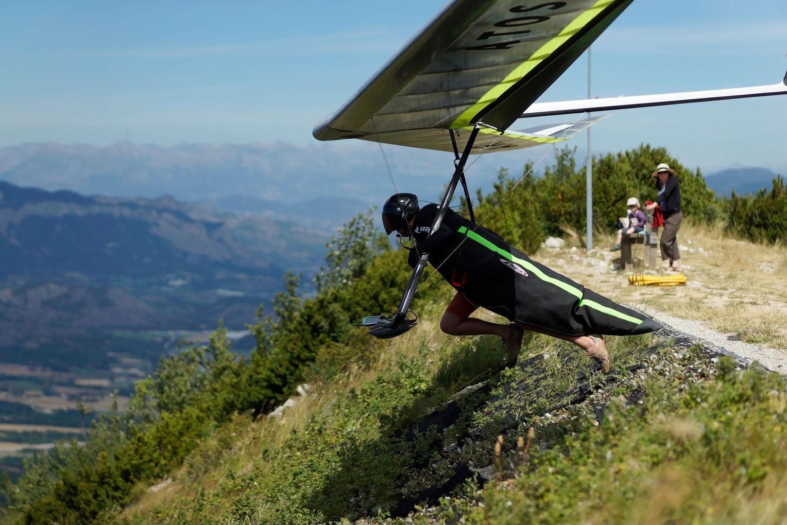 Hang glider pilot prepares to launch from a mountain ridge